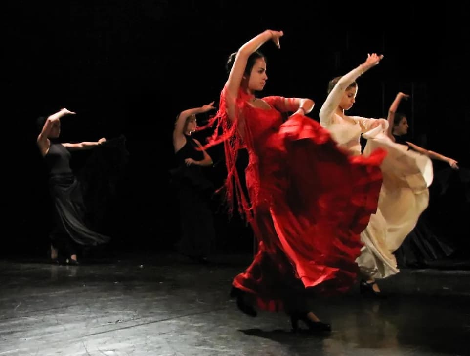 Bailaora de flamenco con bata de cola roja en pleno giro