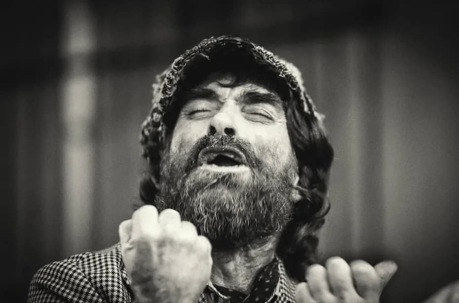 Cantaor de flamenco con los ojos cerrados y el puño en alto, en blanco y negro